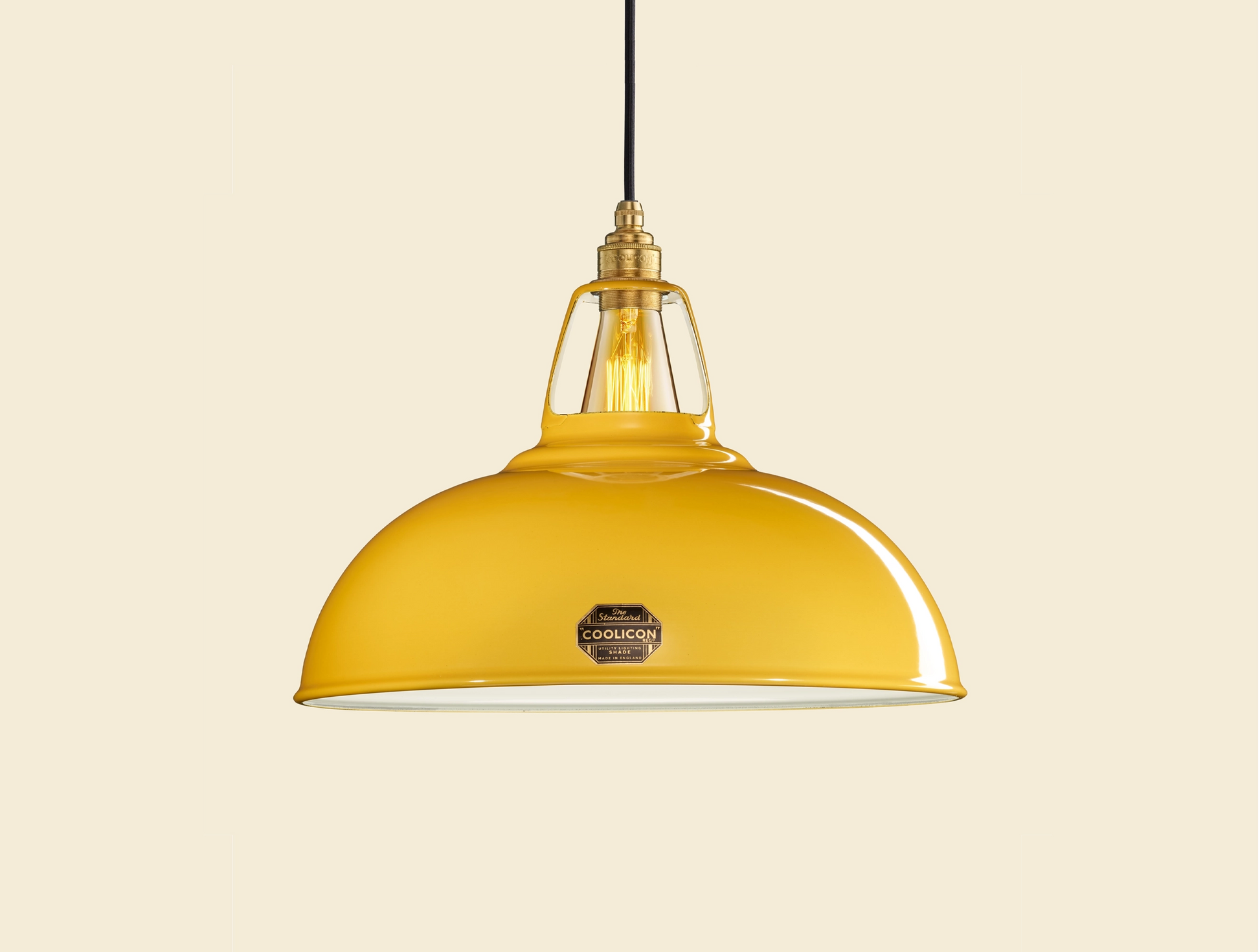 Large Deep Yellow Coolicon lampshade with a Brass pendant set over a yellow background