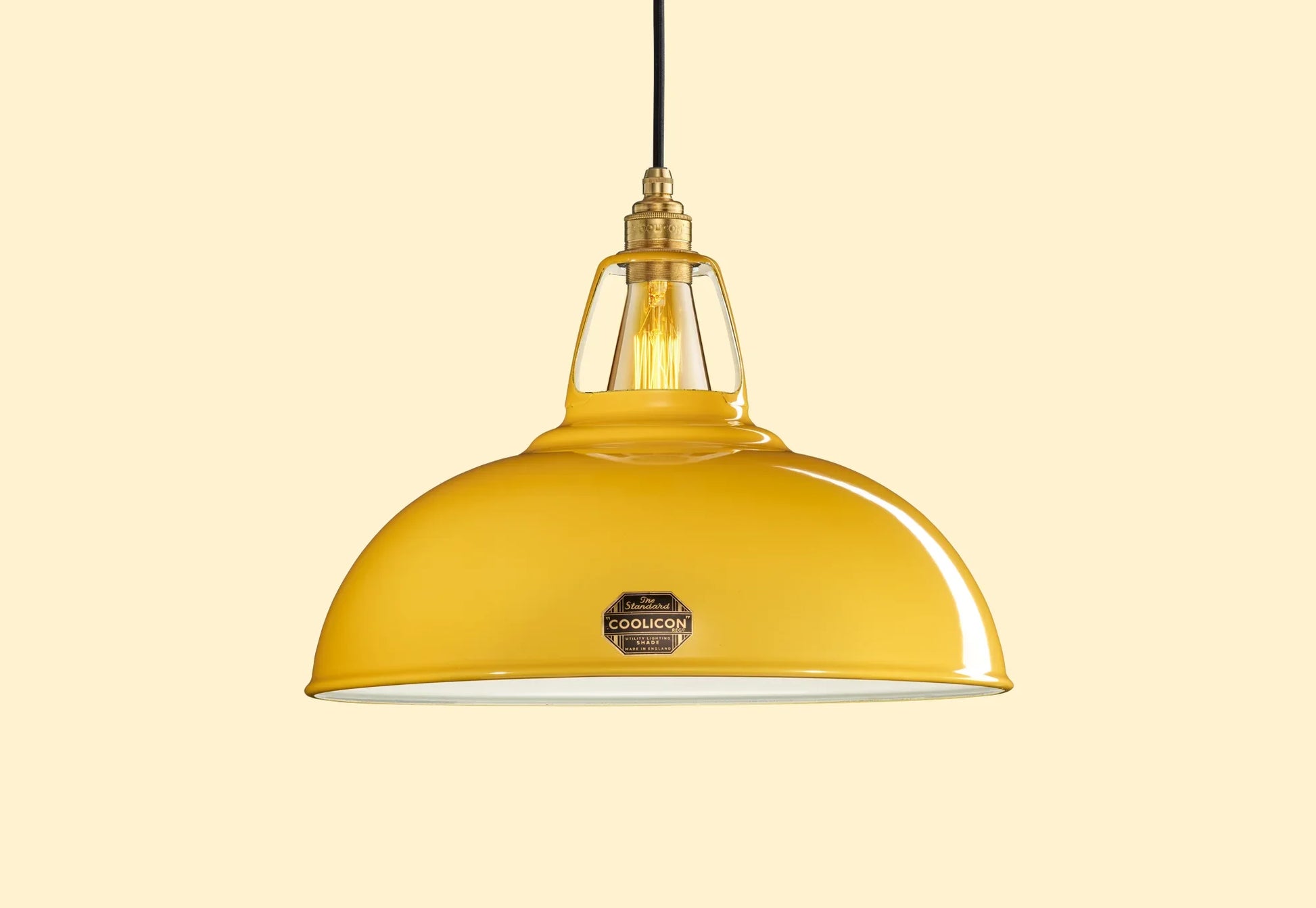 Large Deep Yellow Coolicon lampshade with a Brass pendant set over a yellow background