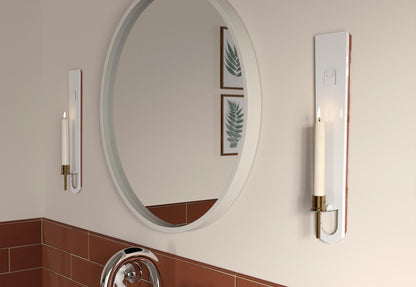 wo candle sconce with a lit candle in a bathroom, next to a mirror