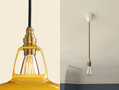Close up of an E14 Signature Brass suspension set on a Deep Yellow lampshade on the left. On the right, an E14 Brass pendant set with a lightbulb is hanging from the ceiling