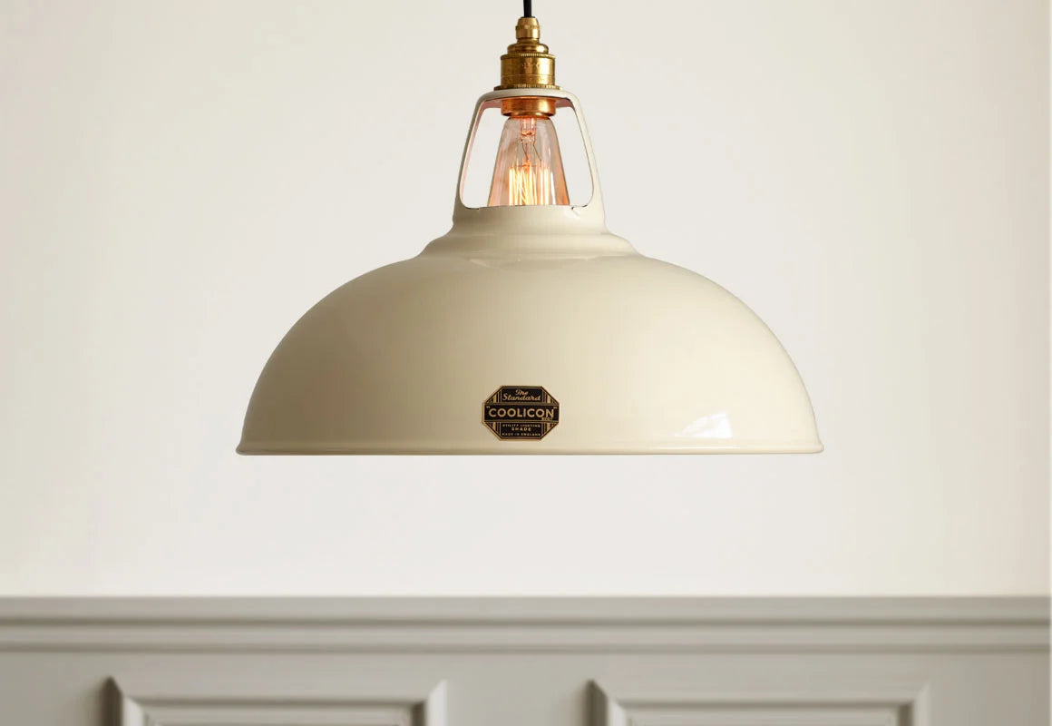 A Large Coolicon Classic Cream lampshade hanging in front of a light cream wall with grey moulding