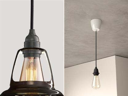 Close up of an E27 Industrial suspension set on a Pewter lampshade on the left. On the right, an E27 Industrial pendant set with a lightbulb is hanging from the ceiling