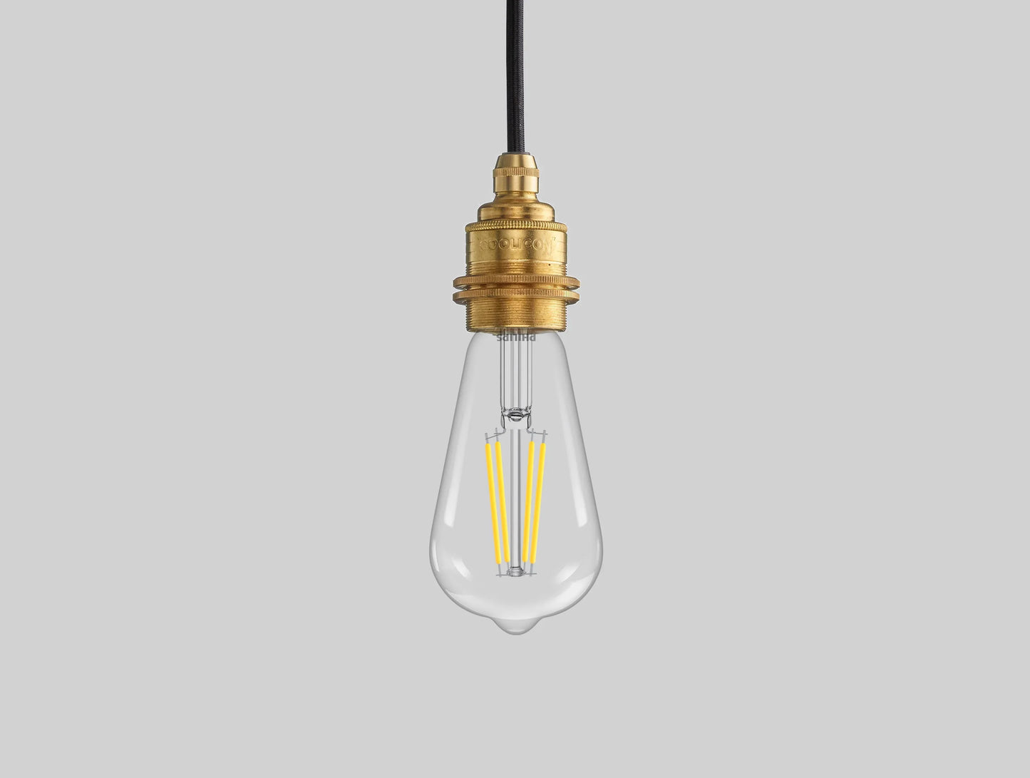 E27 LED Lightbulb hanging over a black background. The lightbulb is fitted with a Coolicon Brass Suspension Set