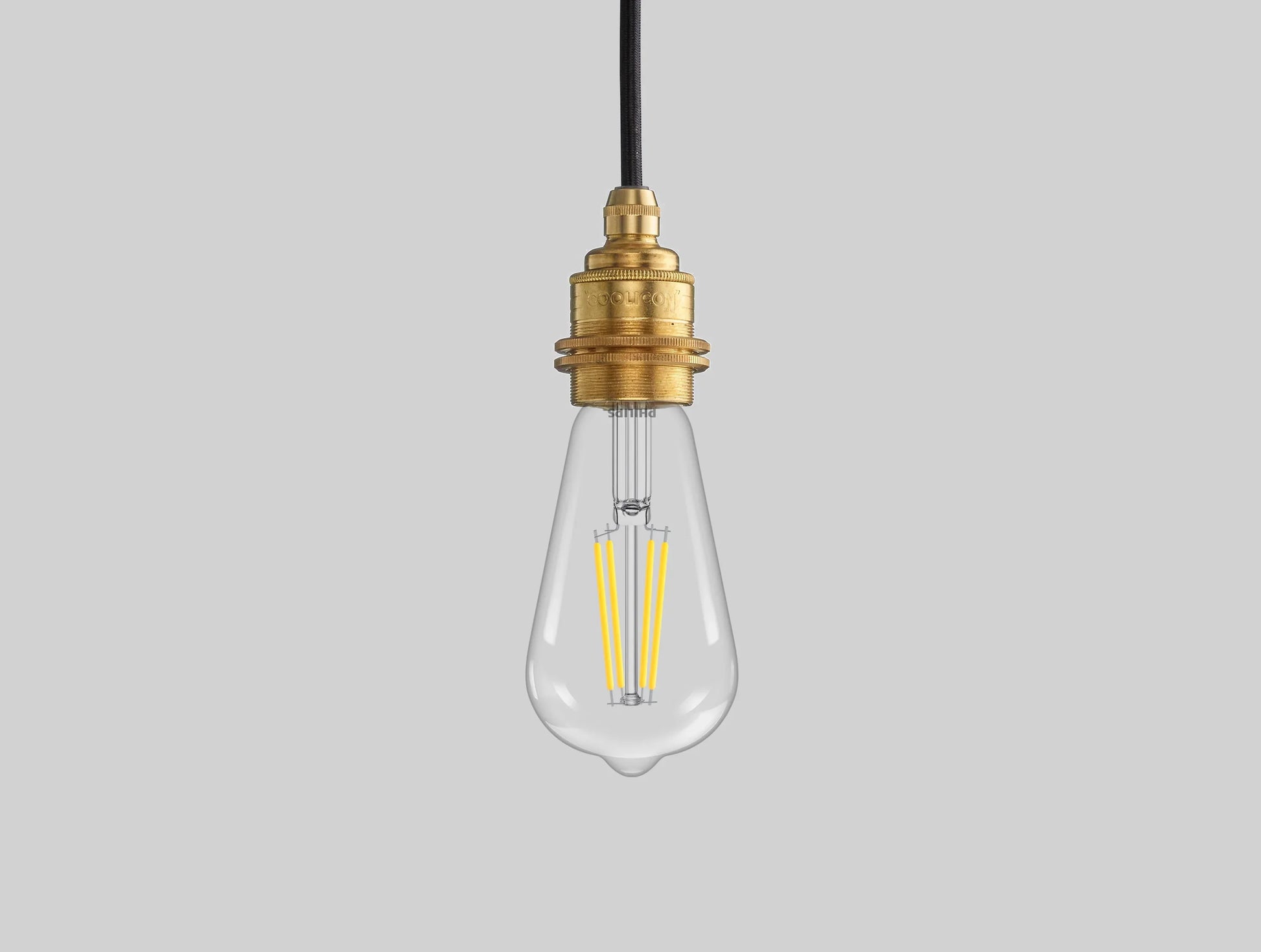 E27 LED Lightbulb hanging over a black background. The lightbulb is fitted with a Coolicon Brass Suspension Set