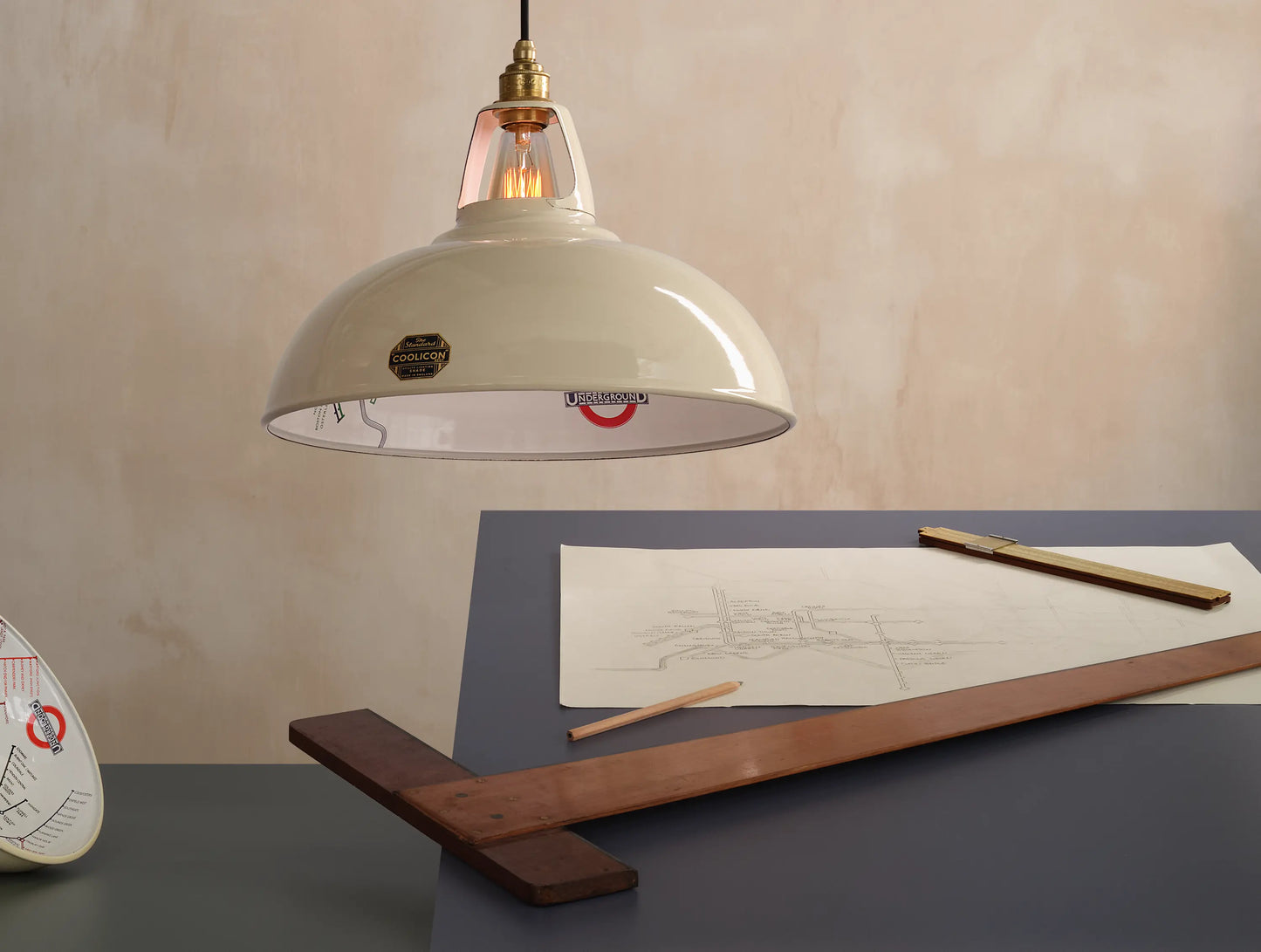 A Large Paper Cream shade over a table. There is a T-square ruler underneath and a pencil sketch of the London Underground map